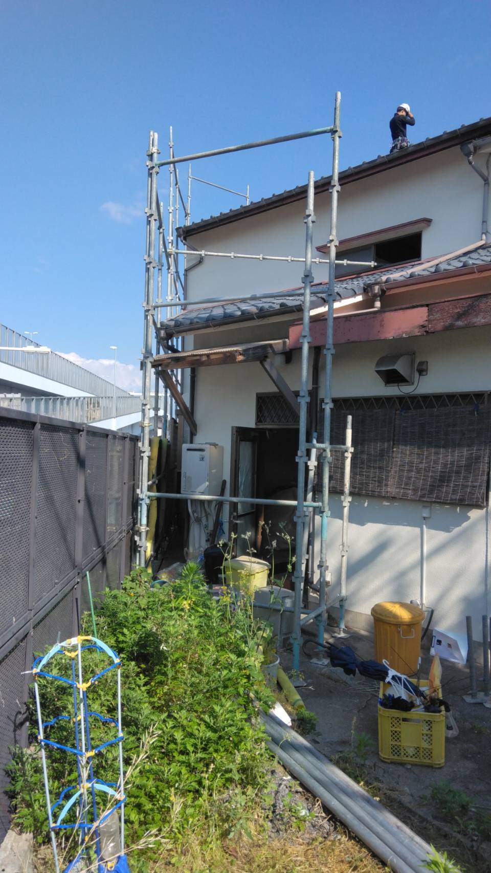 梅林5丁目の解体現場・足場上で屋根の確認をする職人