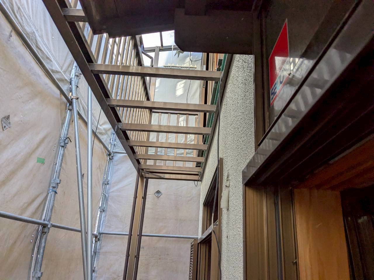 百道1丁目の解体現場・足場と養生シートが組み上がった建物外観・防犯カメラ作動中の掲示