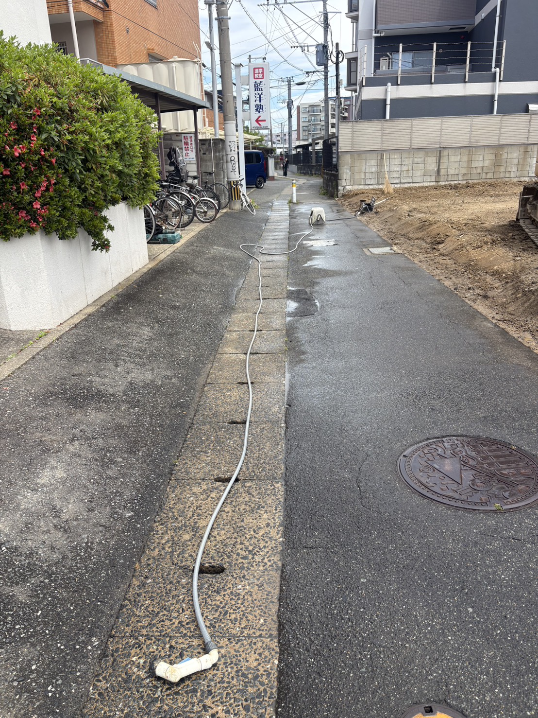 今宿駅前 散水後の道路(粉塵対策・近隣配慮の様子)
