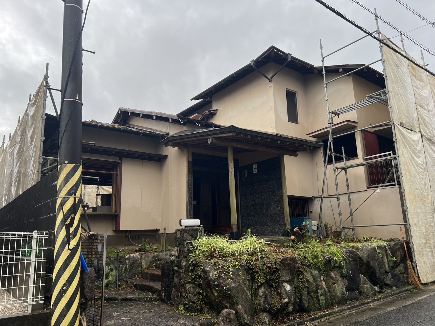 福岡市南区和田の解体現場。足場と養生シートの設置が進み、瓦の手降ろしが始まった木造2階建て住宅