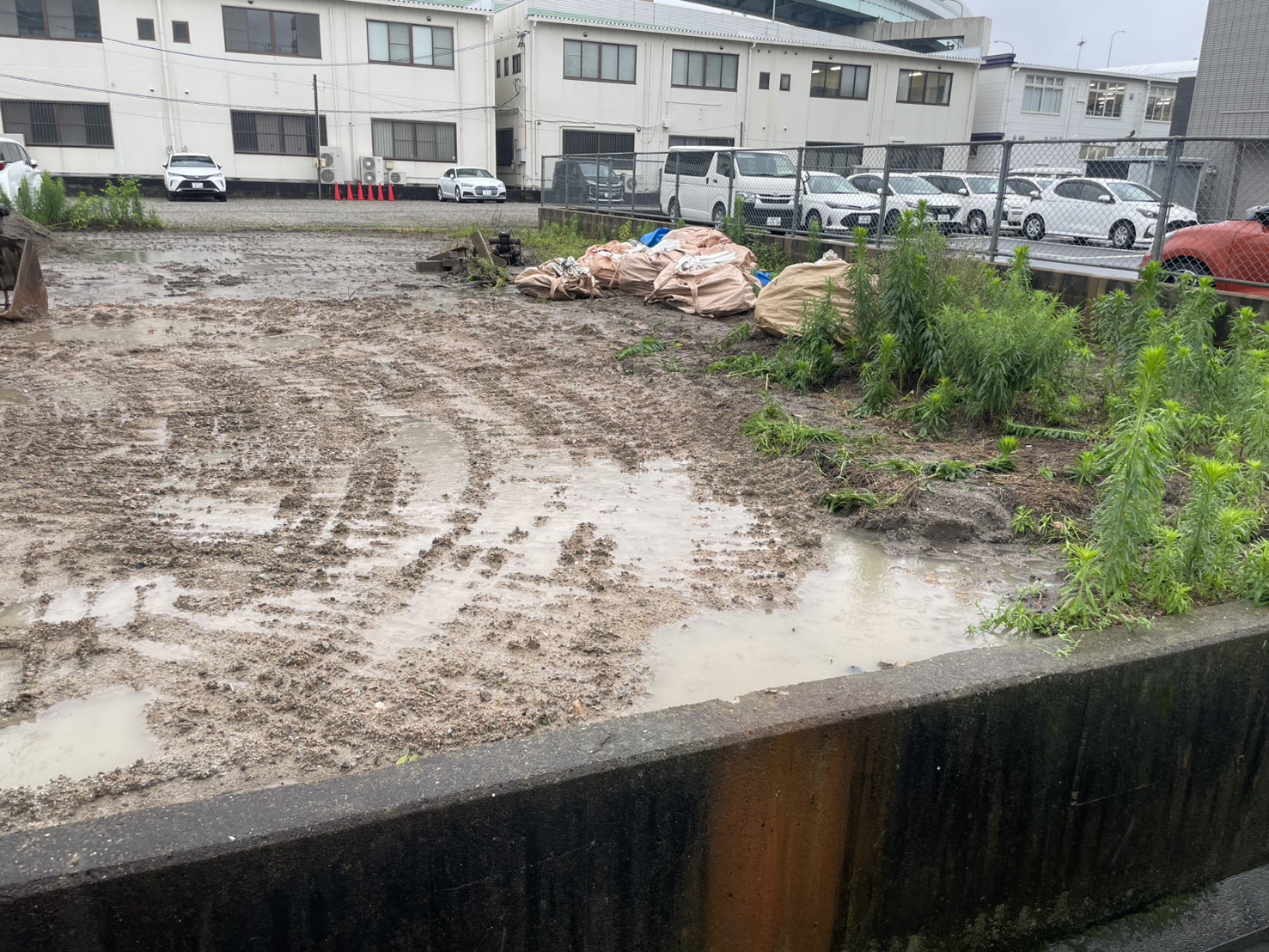 整地が進む現場の全景と分別済みのフレコンバッグ