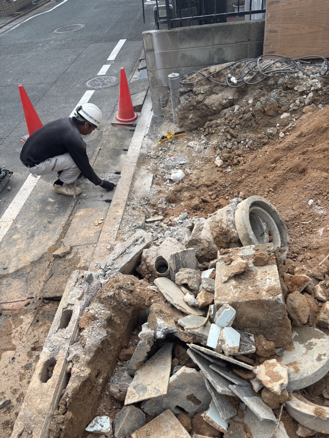 道路際で慎重に作業を進める解体現場の様子