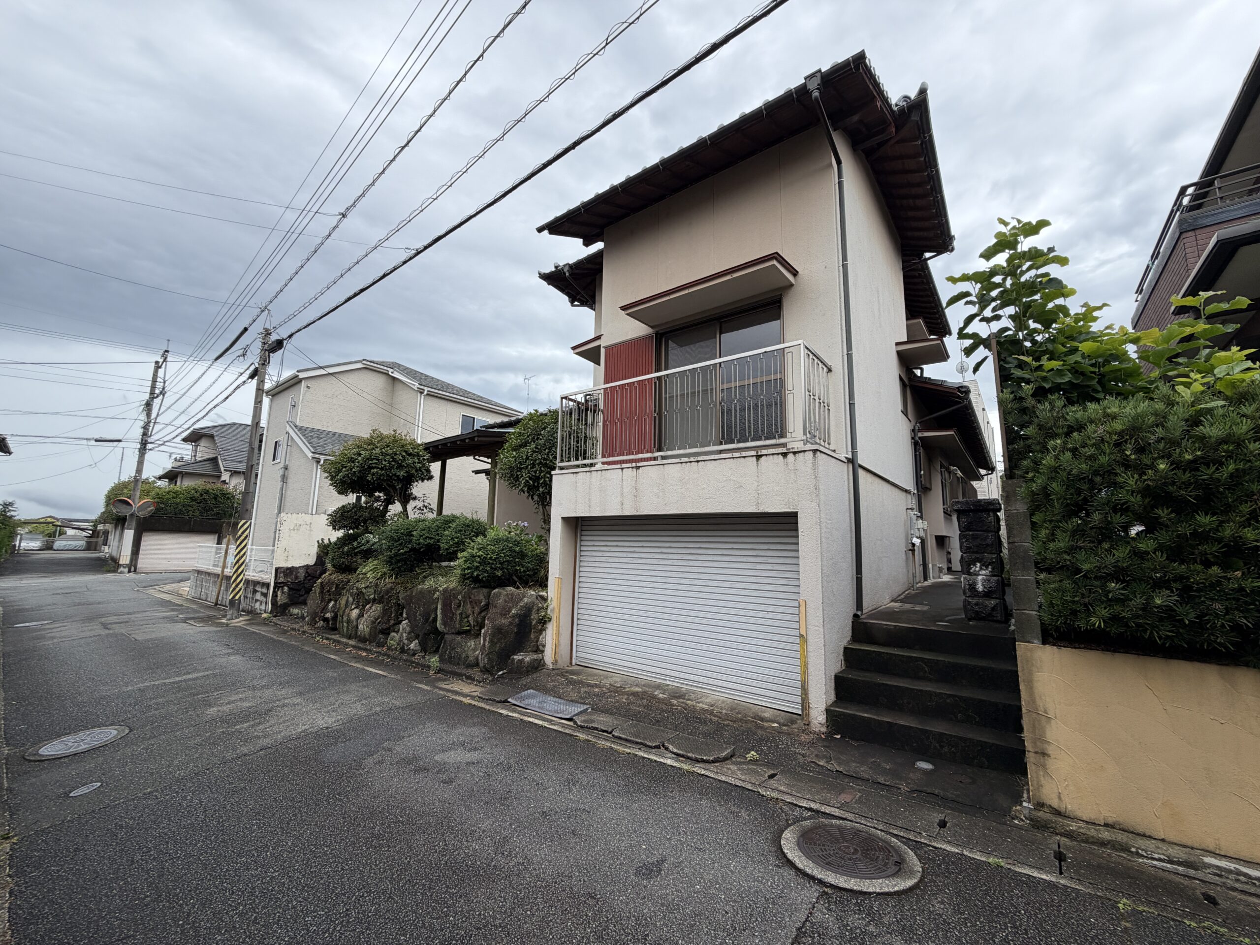1階に組み込まれたガレージと、玄関へ続く外階段