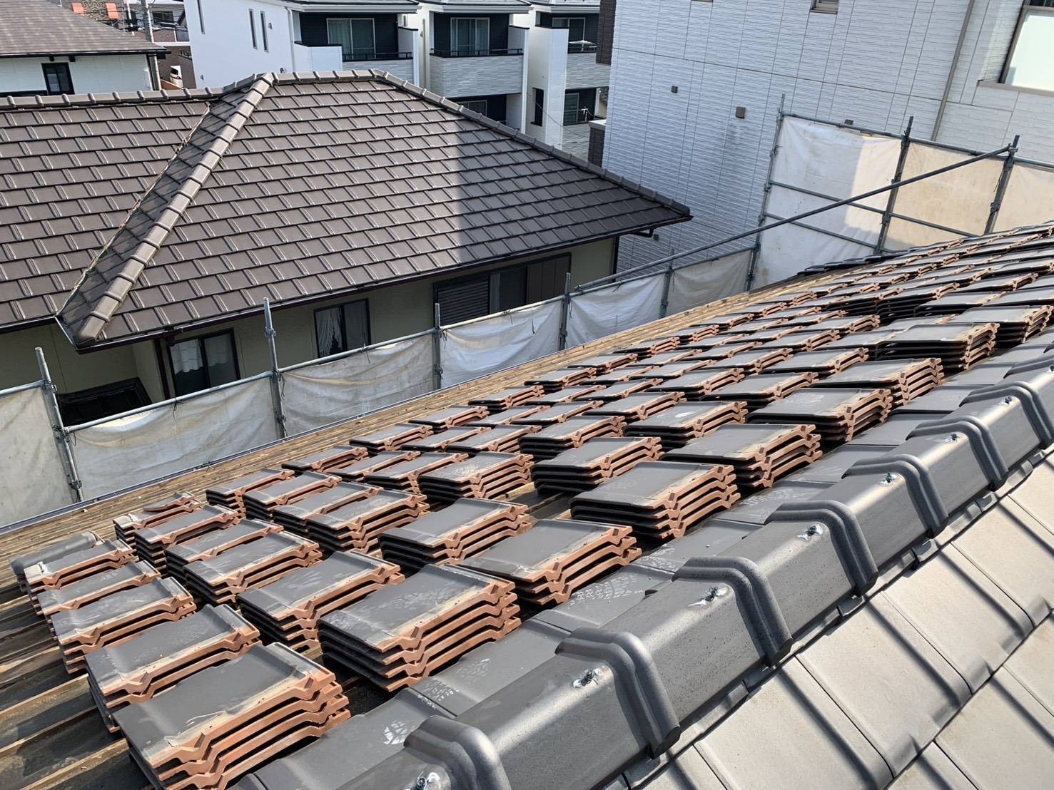 屋根の瓦を手作業で外し、丁寧に仕分けていく様子