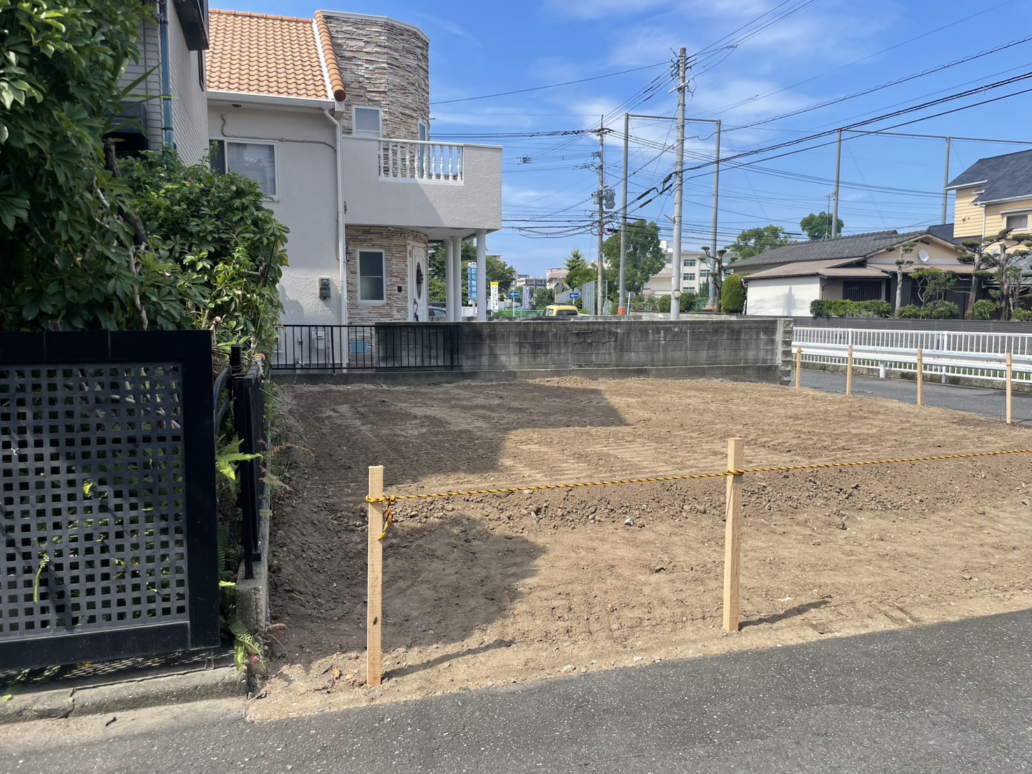隣家側から見た解体完了後の敷地。周囲の住宅と道路の様子
