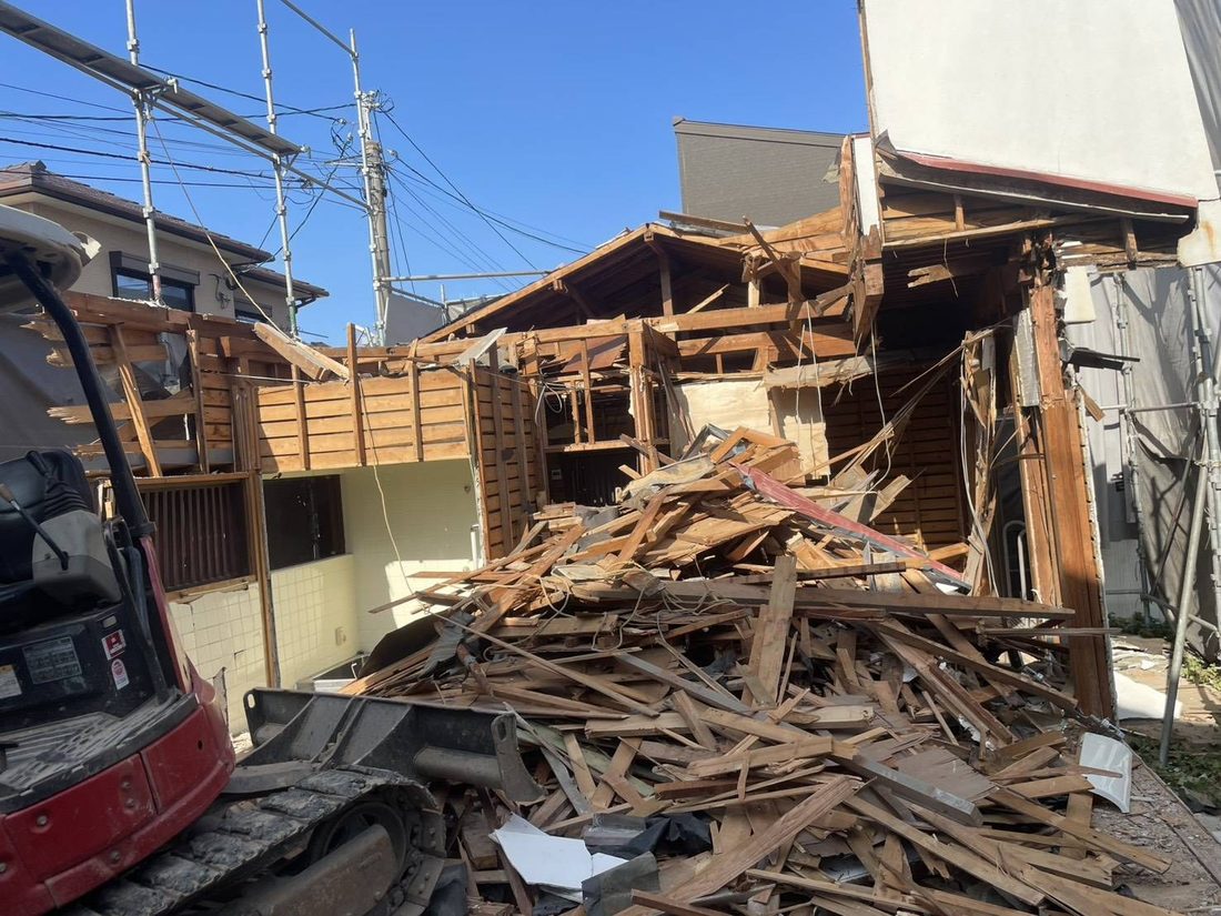 福岡市早良区・賀茂の解体現場。手作業で解いた柱や梁が積み上がっている