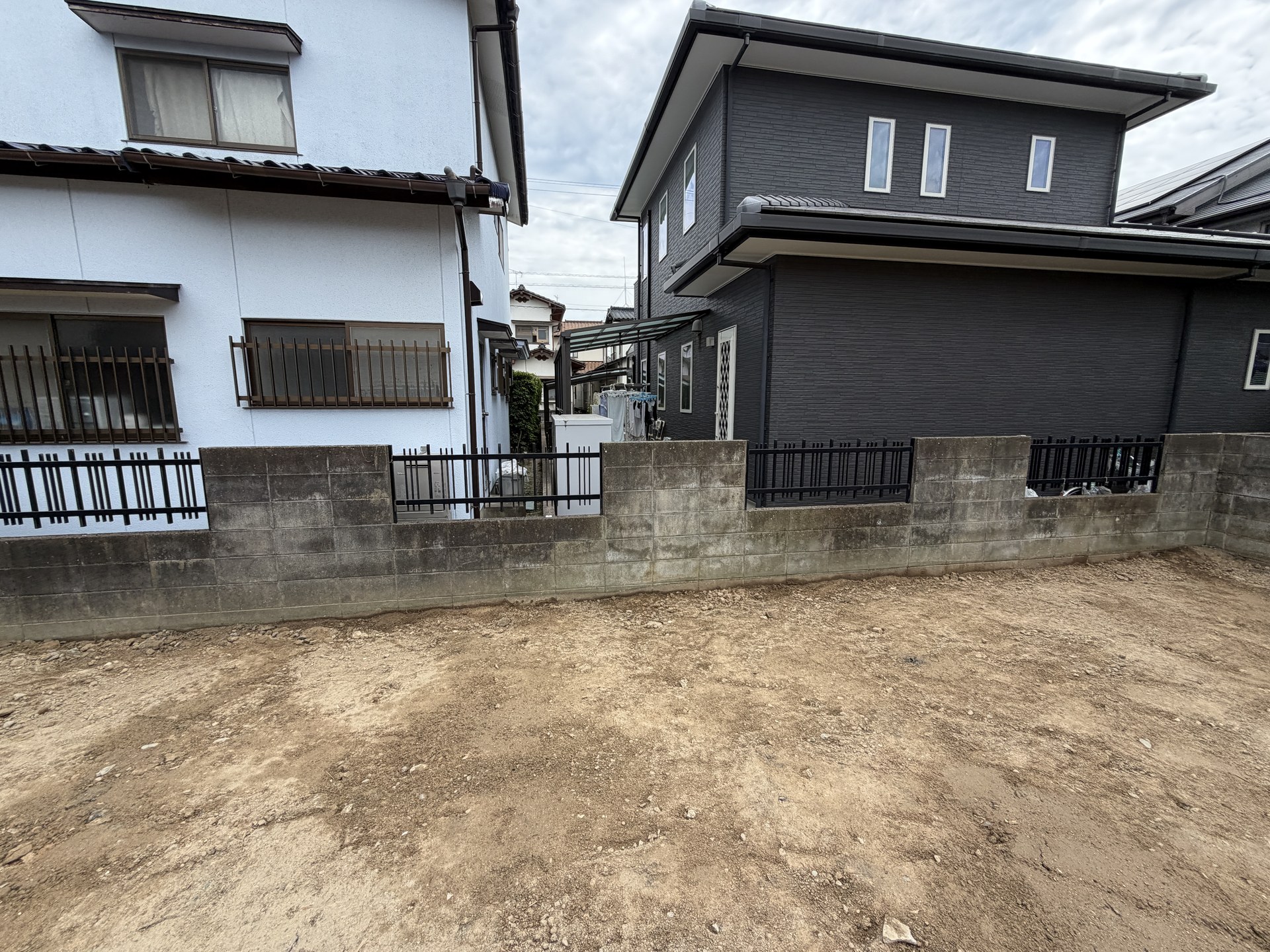 解体後の更地と隣接する住宅。周囲の街並みがわかる