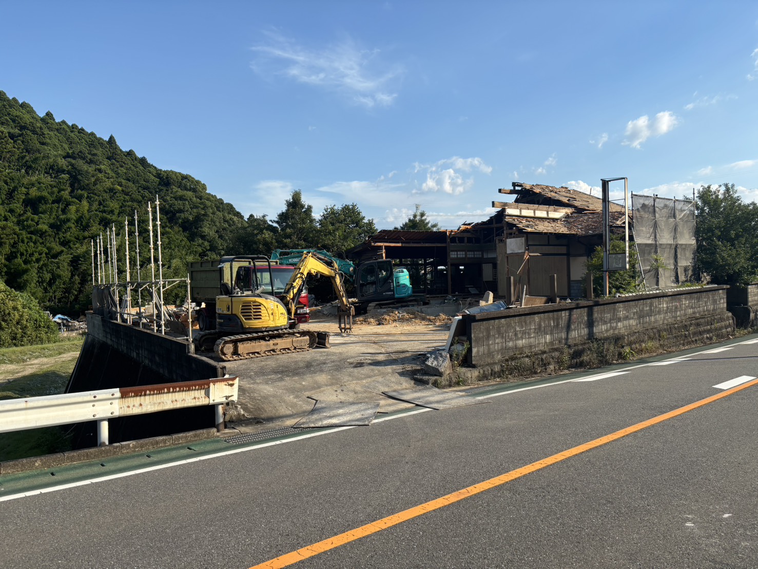 筑紫野市大石の解体現場で作業する重機3台。上屋の解体が進む