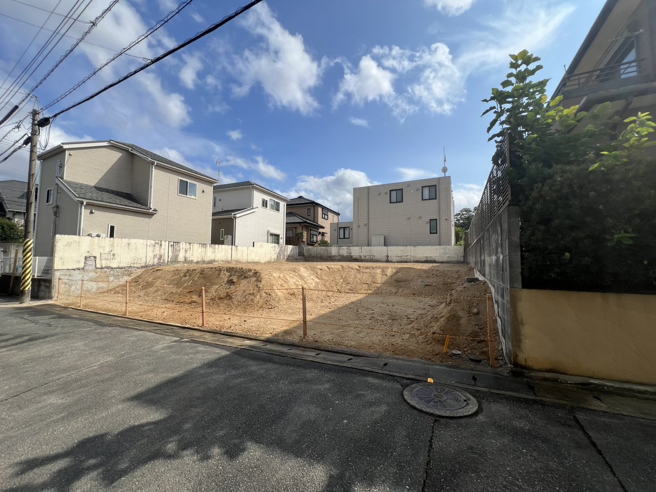 斜め方向から見た和田の解体完了後の敷地。隣地の生垣と敷地境界の様子