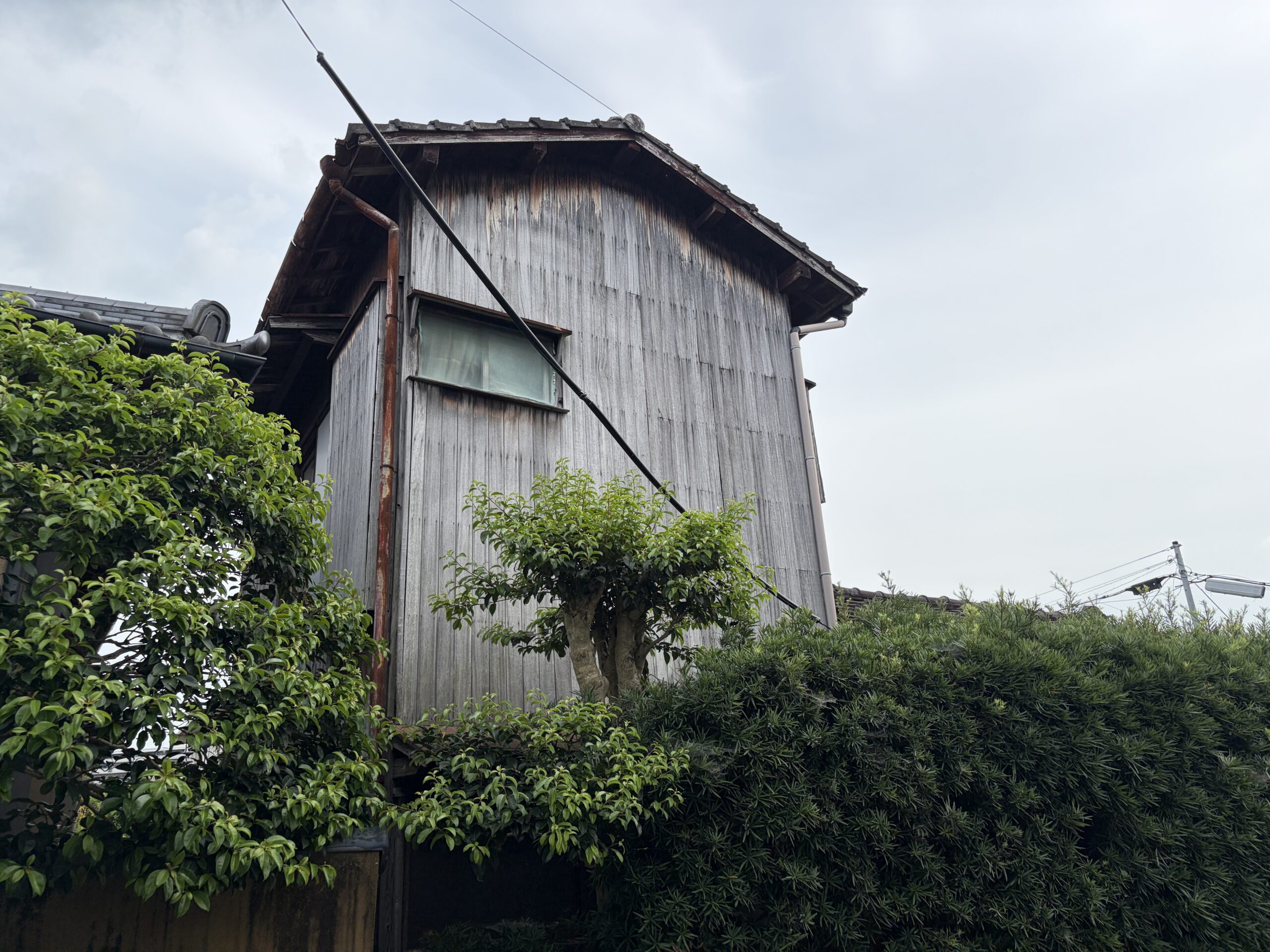 離れの木造建物のクローズアップ、瓦屋根と板張りの外壁