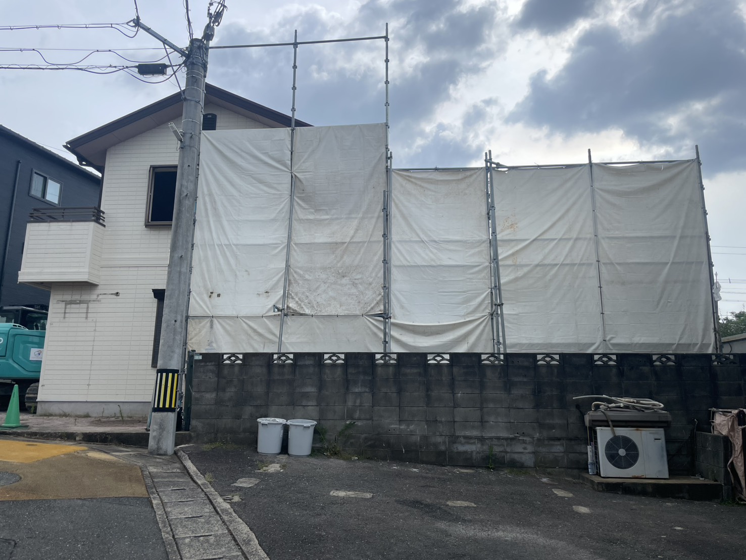 足場と養生シートに覆われた建物の外観