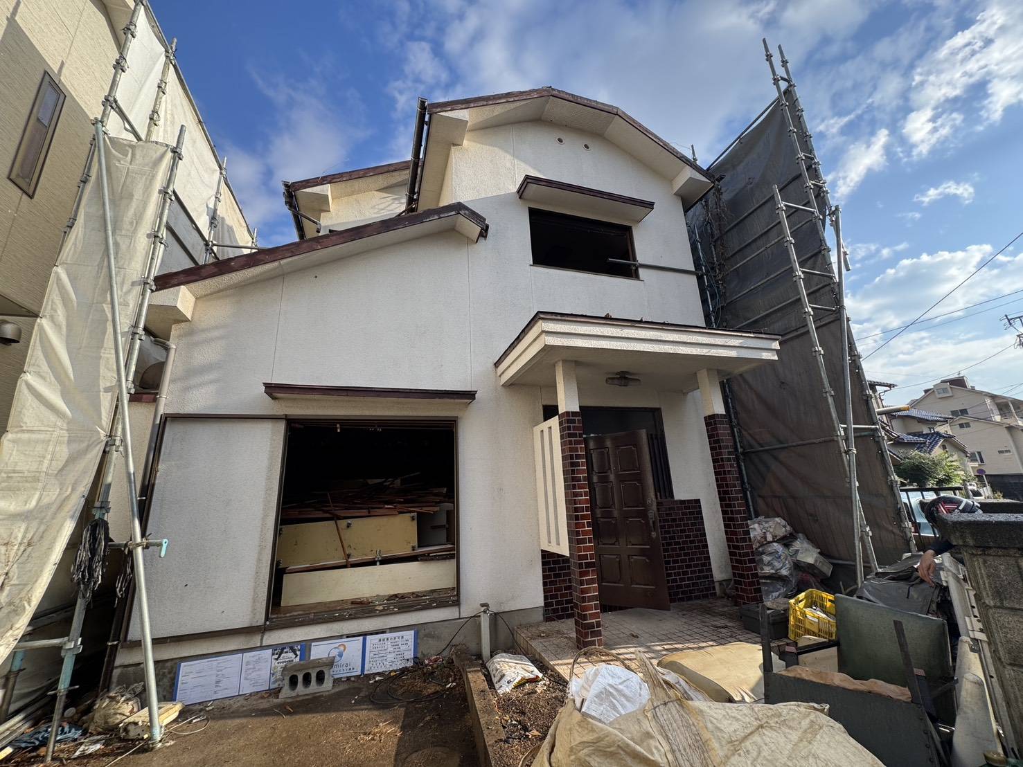 足場とシートに囲まれた、香椎駅東の木造2階建て住宅