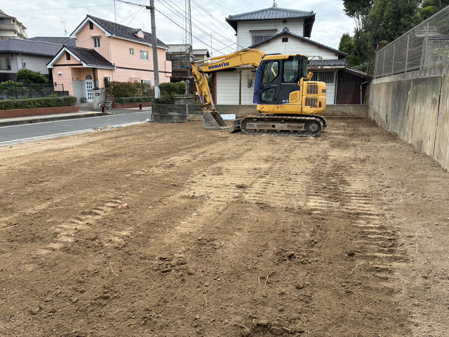 整地を終えた春日市須玖南の現場と、敷地の端に待機する重機