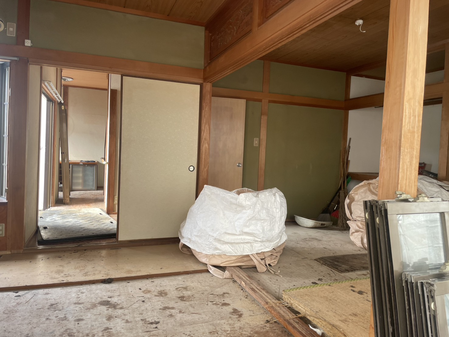 畳を上げ、建具を外した室内。サッシと袋に分けた廃材