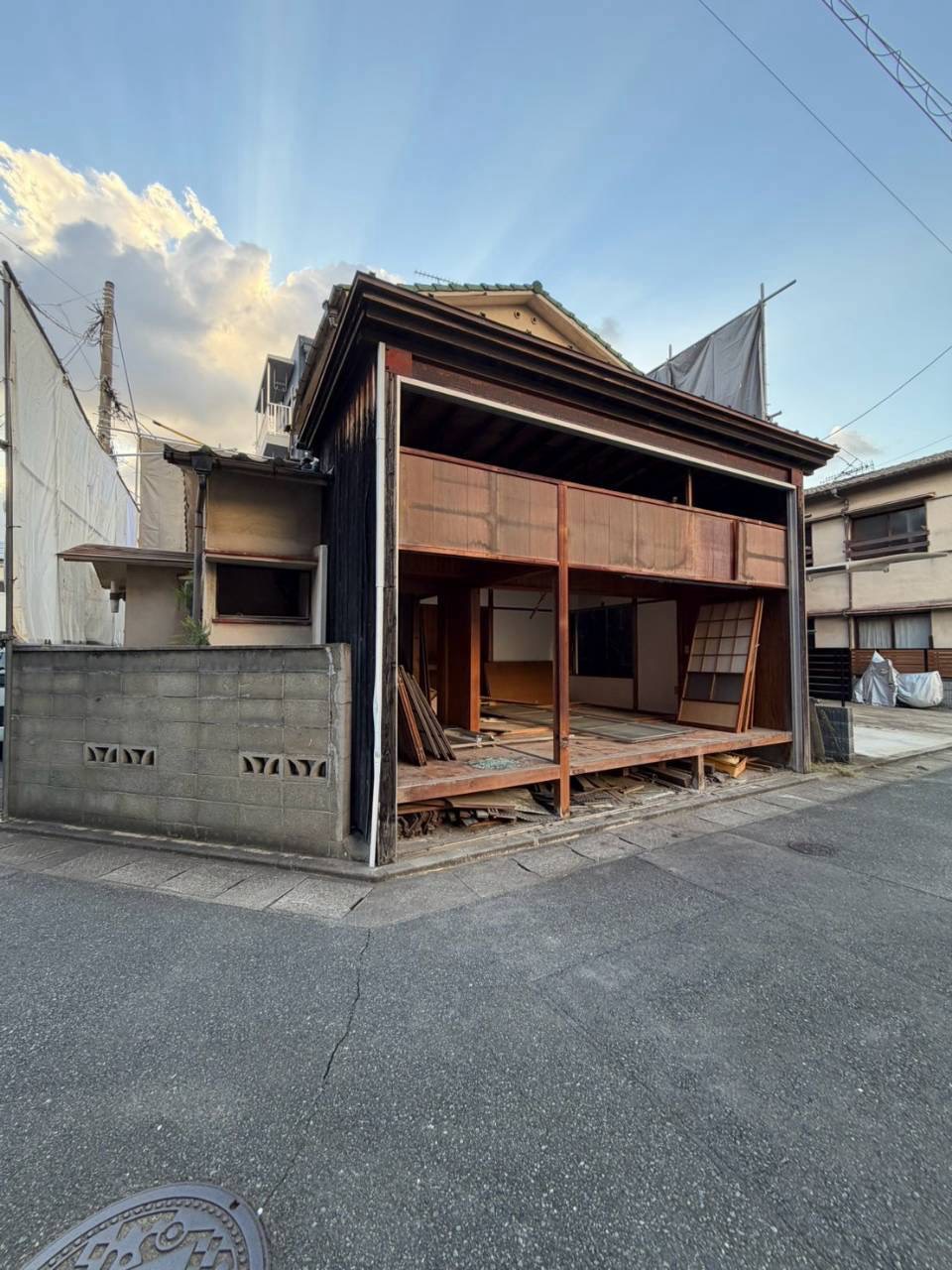 正面の建具を外し、中の床が見える古い木造2階建て