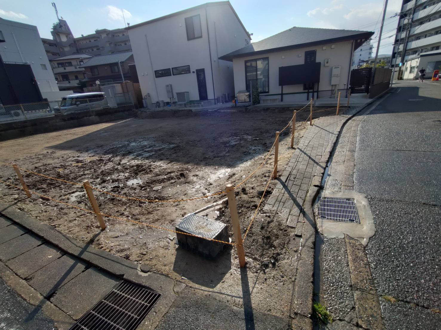 交差点の側から見た、杭とロープで囲った更地
