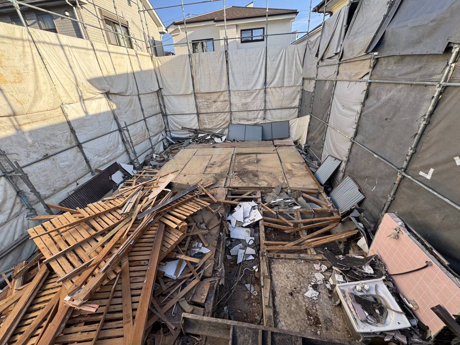 床をはがし、建物の下の木の土台が見えている様子