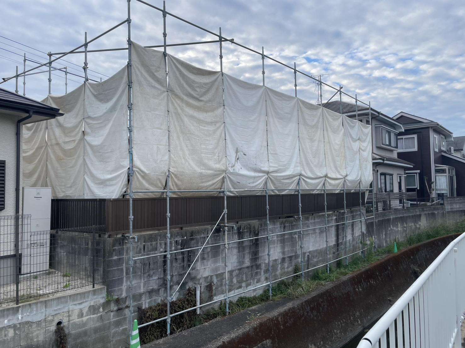 建物がなくなったあとも、水路側に残した足場と養生シート
