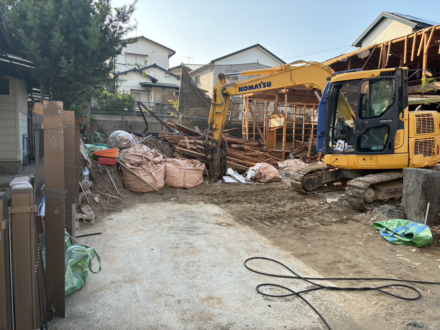 足場とシートで囲われた建物を、重機で解体している様子