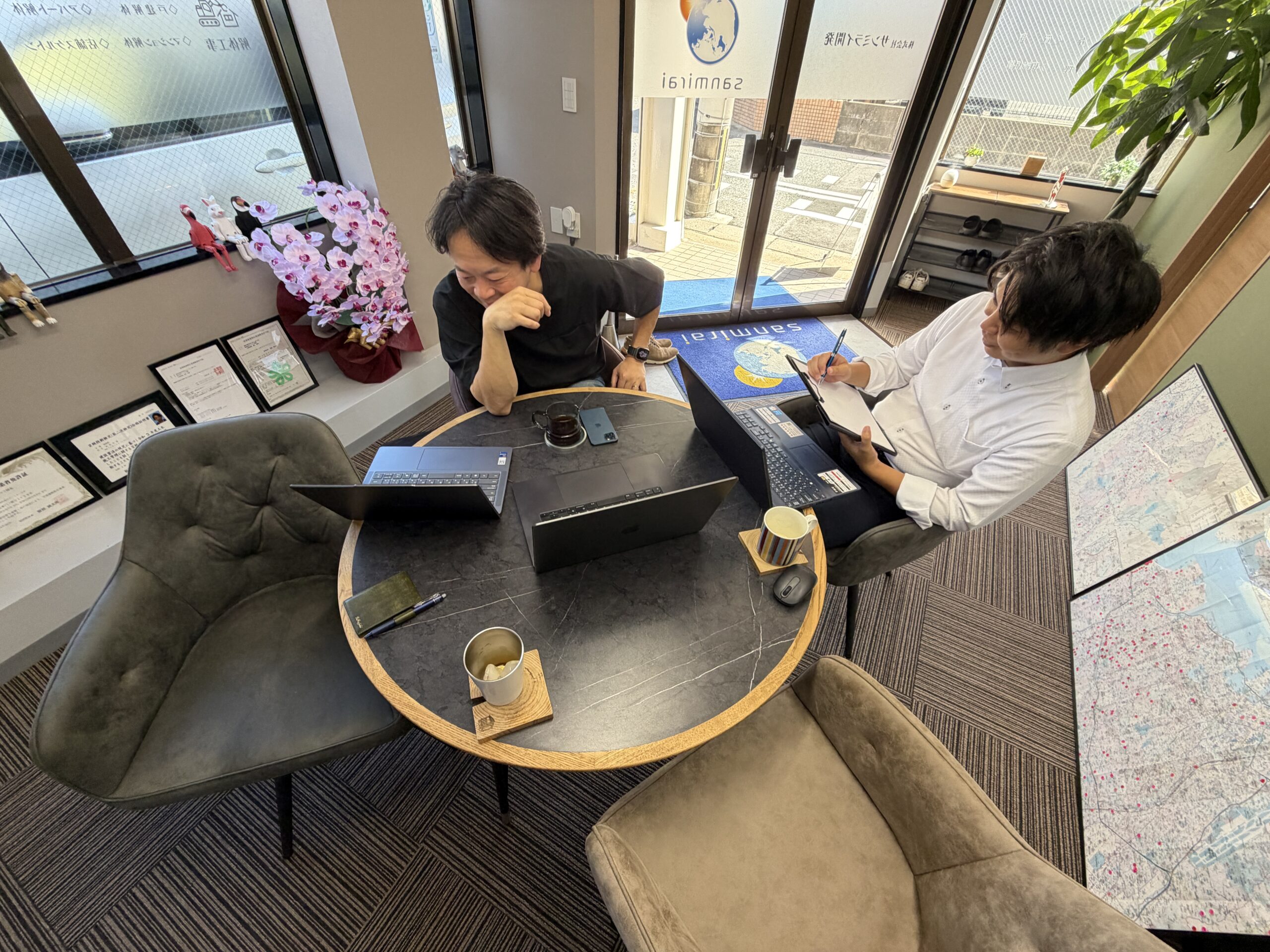 窓ぎわの席で、吉田さんの説明を聞きながらメモを取る様子